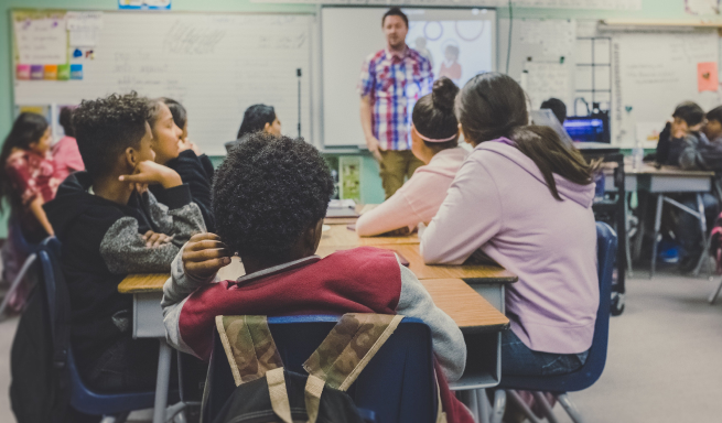 A students sits in class listening to his teacher.