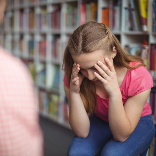 A student holds her head in her hands